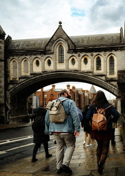 A stone bridge with arched walkways and a person walking under it. 4