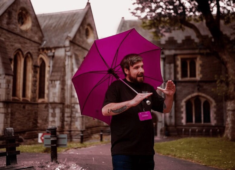A person holding a purple umbrella in front of a historic building. 1