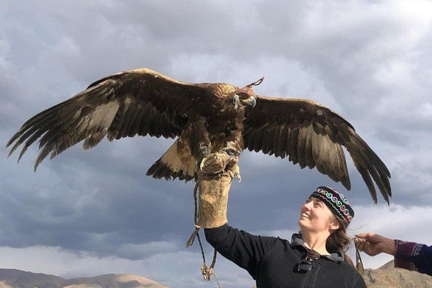Une personne tenant un grand oiseau de proie, les ailes déployées. 3