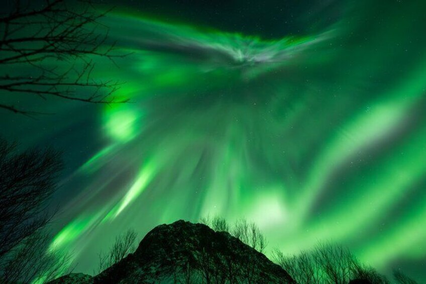 The Northern Lights over a mountainous landscape. 2