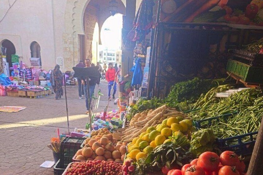 Un mercado con productos frescos, incluyendo tomates, limones y judías verdes. 3