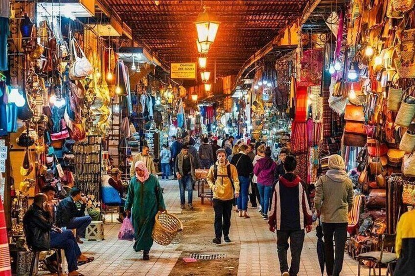 A bustling market with people walking through aisles filled with various goods. 3