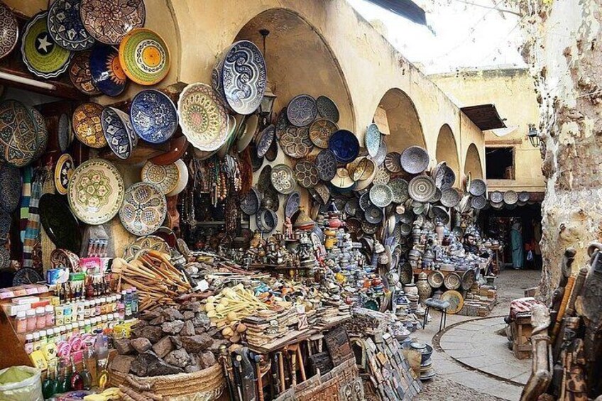 A market with colorful pottery and various items for sale. 5