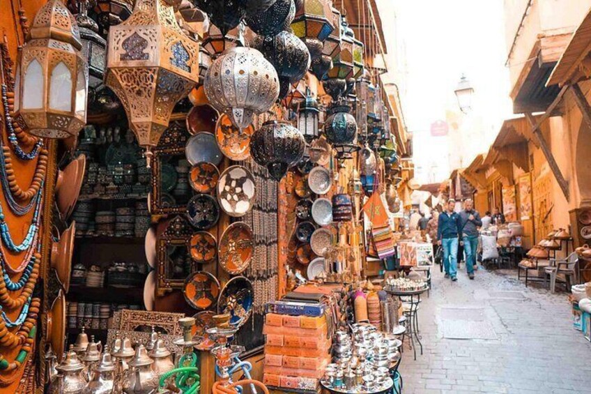 A bustling market with various stalls selling pottery, lanterns, and textiles. 2
