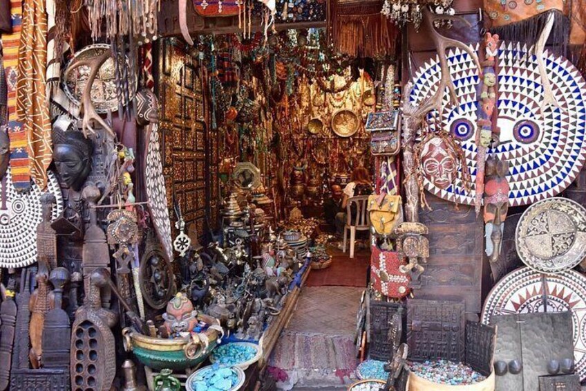 A narrow market with various items on display, including pottery, textiles, and decorative objects. 1