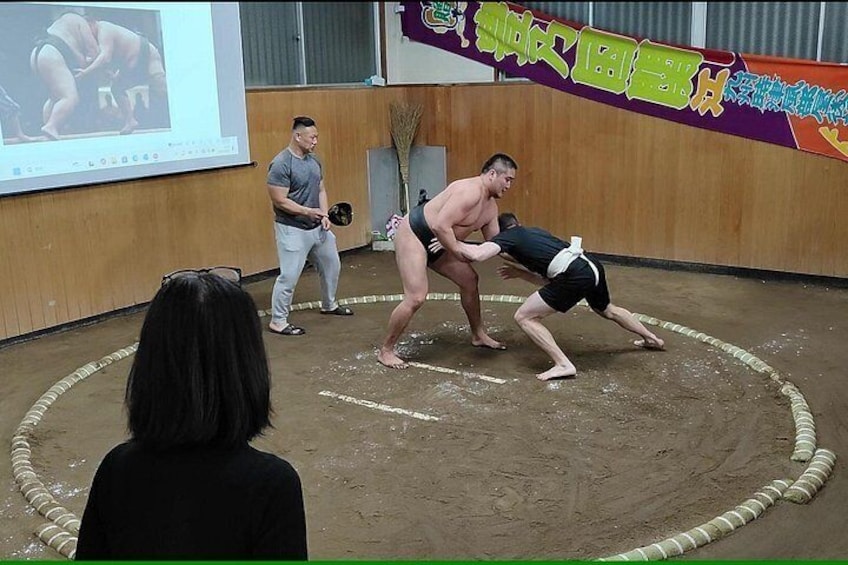 Un combate de sumo con dos luchadores y un público. 5