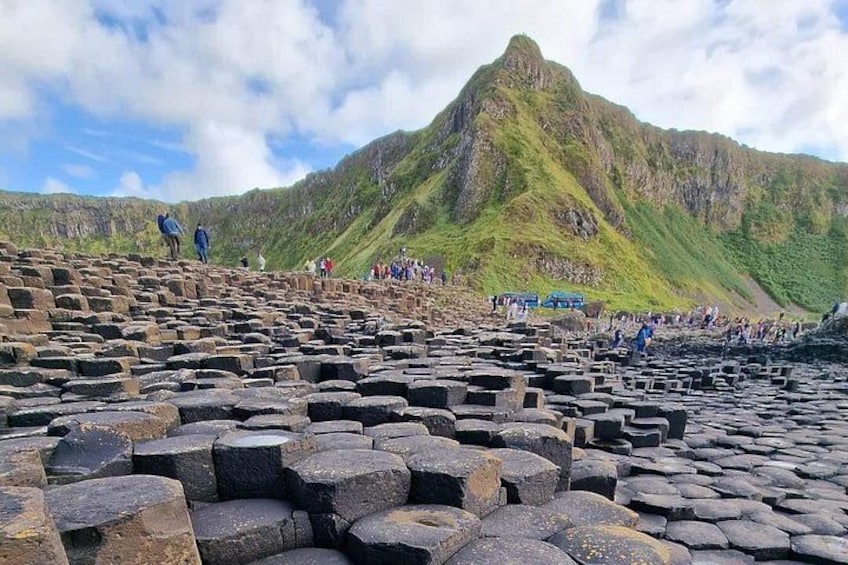 Una gran estructura de piedra con gente caminando encima. 5