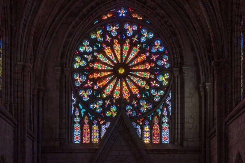 A large stained glass window with intricate designs and a central rose window. 4