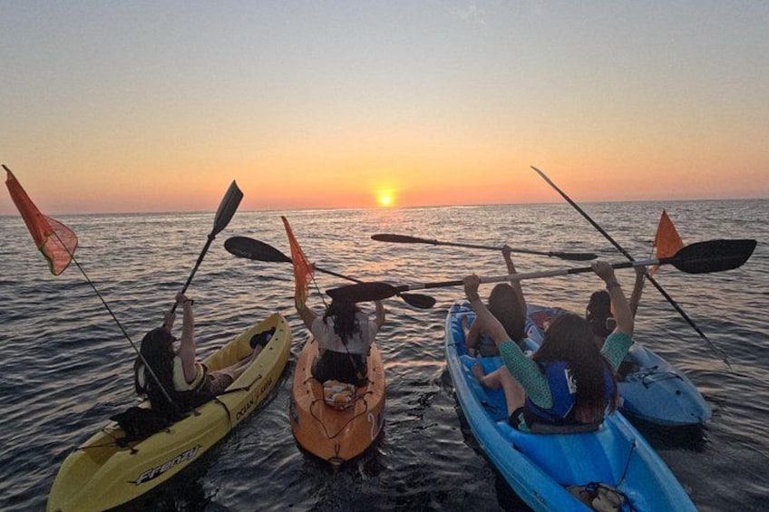 Three kayaks on calm water at sunset. 1