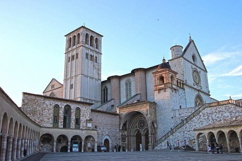 A historic church with a bell tower, arched windows, and a staircase leading to the entrance. 4