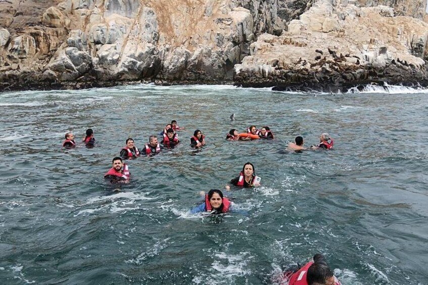 Un grupo de personas nadando en un río con acantilados rocosos al fondo. 2