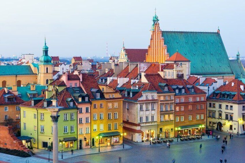 Ett historiskt torg i en europeisk stad, med färgglada byggnader och ett framträdande kyrktorn. 5