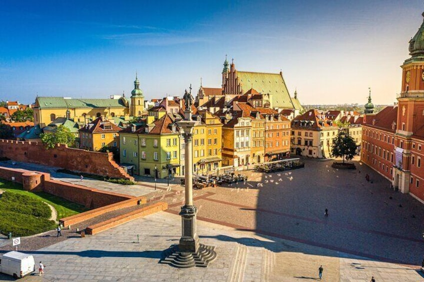 Ett historiskt torg med ett framträdande monument, färgglada byggnader och ett stort, öppet område. 1