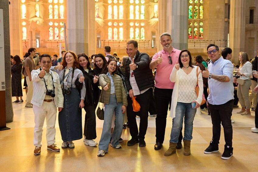 A group of people posing in a church with stained glass windows. 4