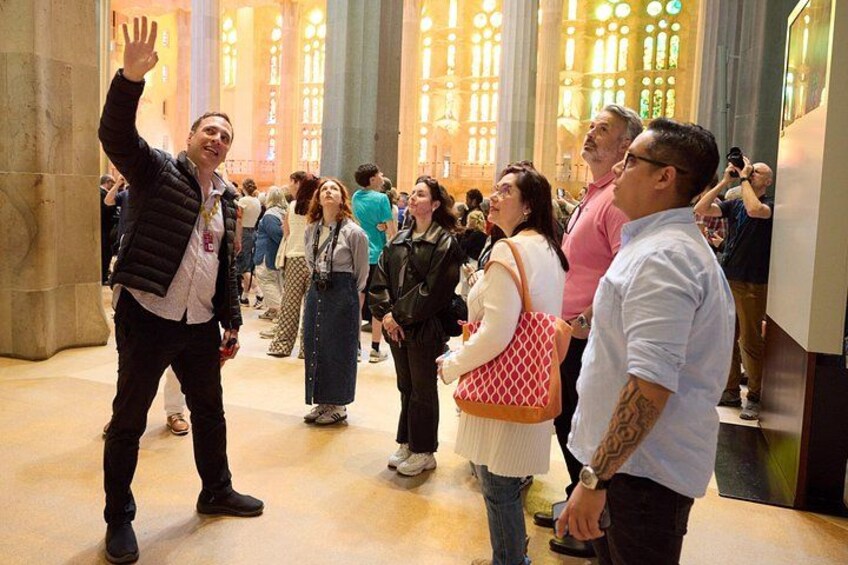 A group of people in a spacious indoor area with high ceilings and large windows. 2