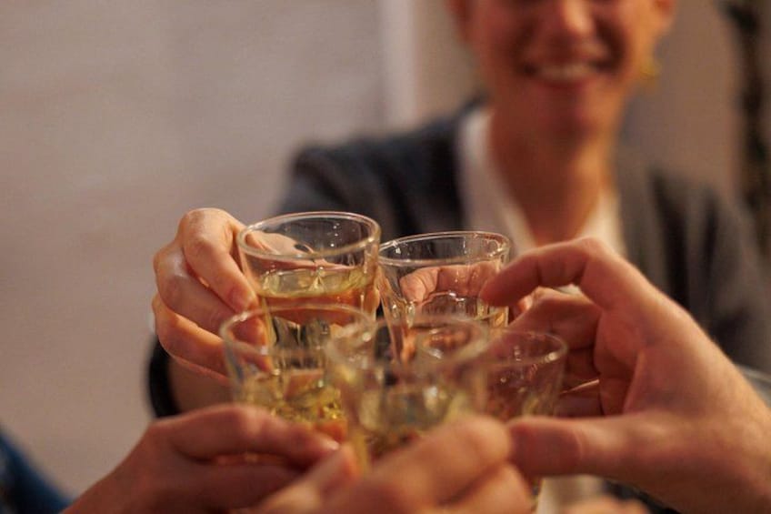 Un groupe de personnes tenant des verres contenant une boisson de couleur claire, probablement en train de trinquer. 4