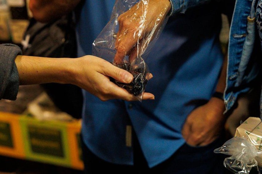 Une personne remet un sac en plastique contenant un liquide sombre à une autre personne. 5