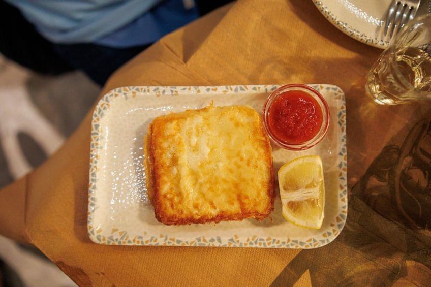 Une assiette contenant un plat pané, un quartier de citron et un petit récipient de sauce. 3