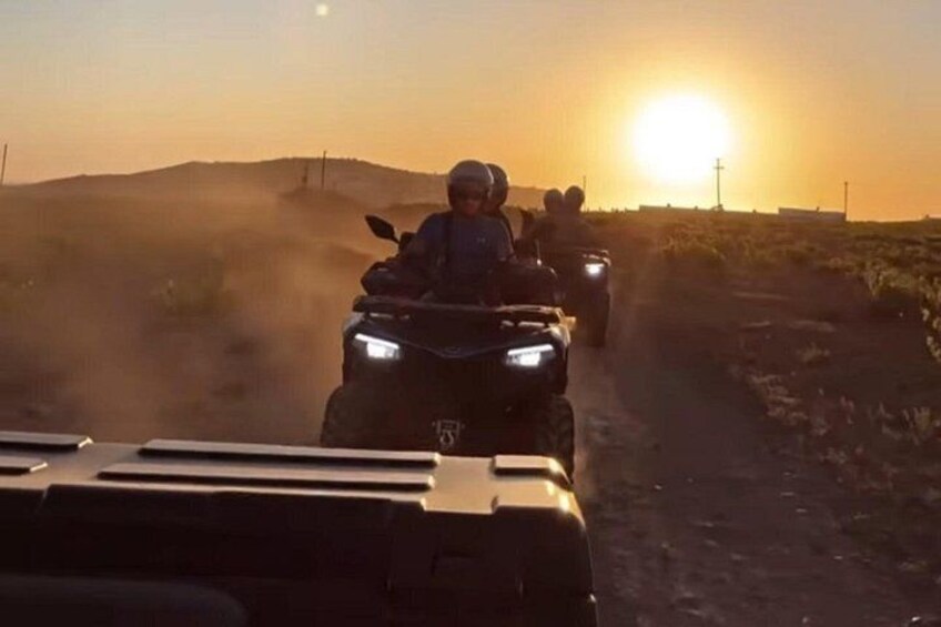Deux véhicules tout-terrain sur un chemin poussiéreux, avec un coucher de soleil en arrière-plan. 2