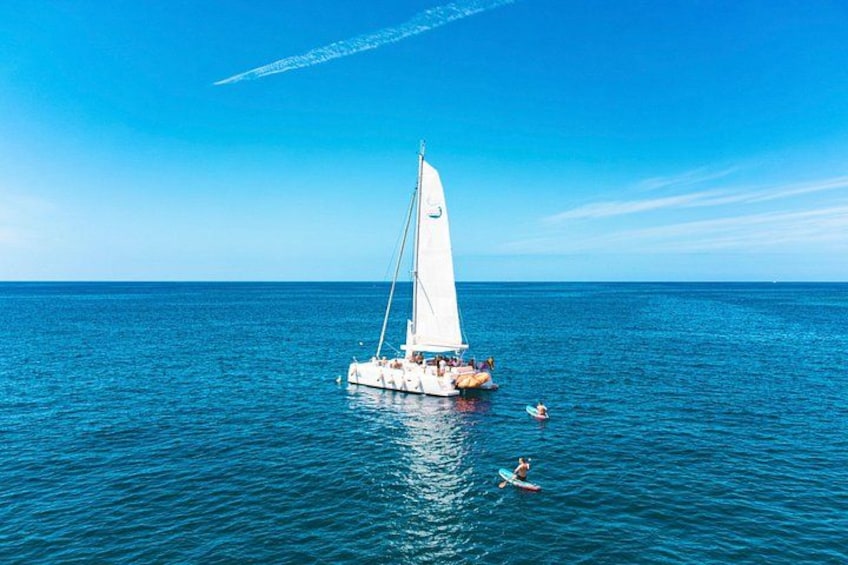 A sailboat on calm blue waters with a clear sky. 1