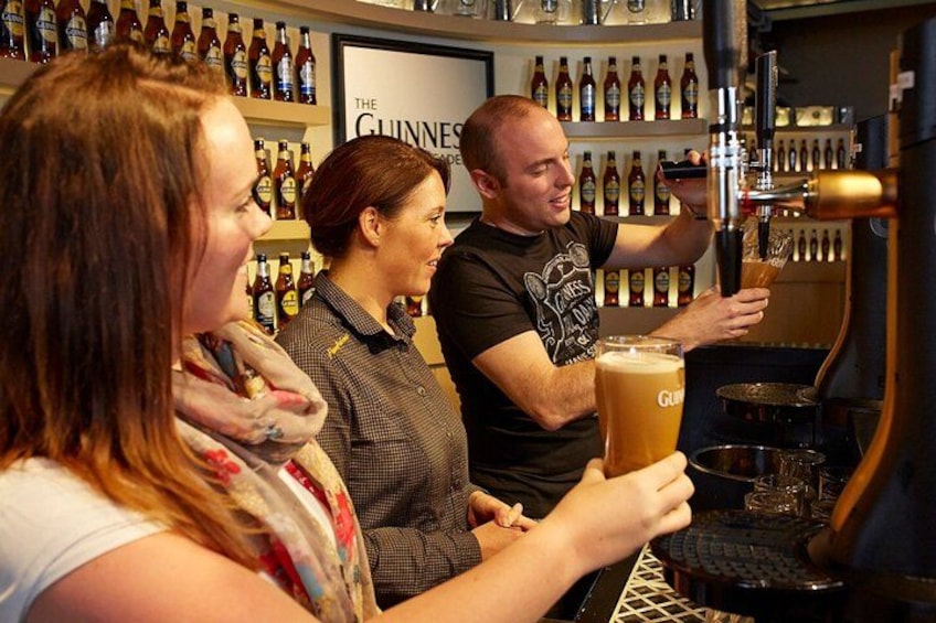 A bar with a person pouring beer into a glass. 2