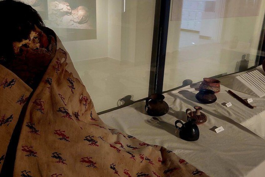 Una vetrina museale con diversi oggetti in ceramica su un tavolo. 5