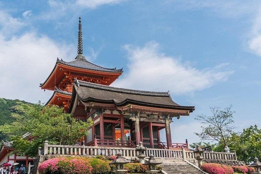 Een traditionele Japanse pagode met een meerlaagse dak, omringd door weelderig groen en een heldere lucht. 5