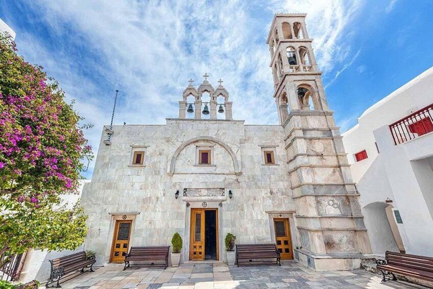 Una iglesia histórica con una torre de campanas, ventanas de arco y un acceso central. 3