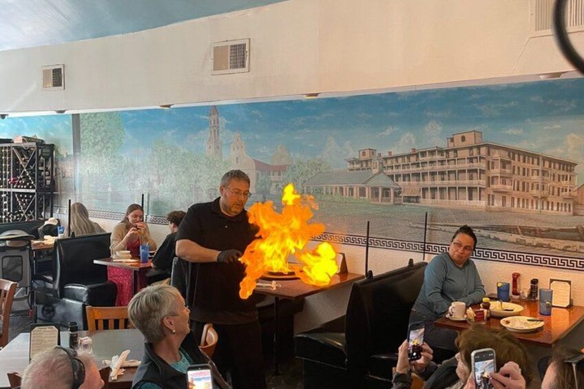 Een restaurant met een muurschildering van een gebouw en een vuurshow. 2