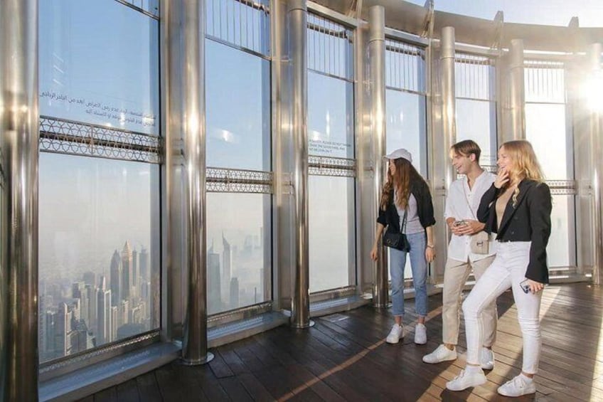 A group of people standing in a modern building with large windows overlooking a cityscape. 2