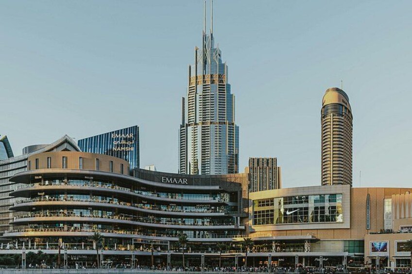 Un horizonte urbano con edificios modernos, incluyendo un rascacielos destacado y una estructura curva con el nombre 'EMAAR'. 4
