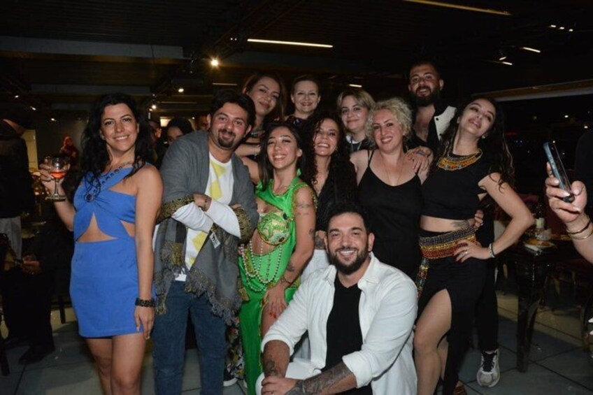 A group of people at an indoor event, some holding drinks. 3