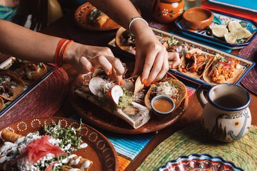 Una persona preparando tacos con diversos ingredientes sobre una mesa de madera. 2