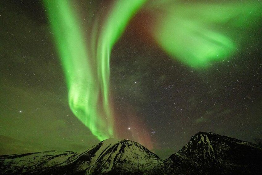 Une chaîne de montagnes sous un ciel nocturne illuminé d’aurores boréales vertes. 3