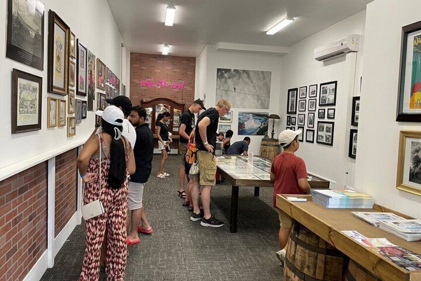 An art gallery with framed pictures on the walls, a brick wall, and a neon sign. 5