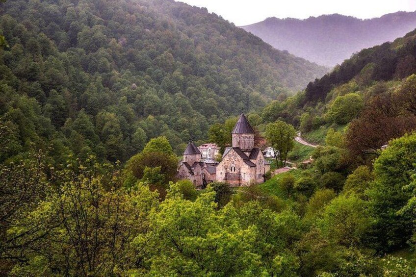 Une église historique, entourée d’une forêt verdoyante et de collines. 2