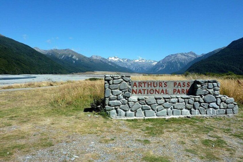 A stone sign for Arthur's Pass National Park with a mountainous backdrop. 1