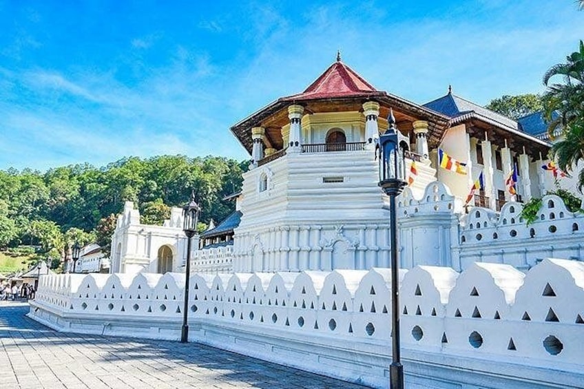 A white temple with a red roof, surrounded by a white fence with pointed tops. 1