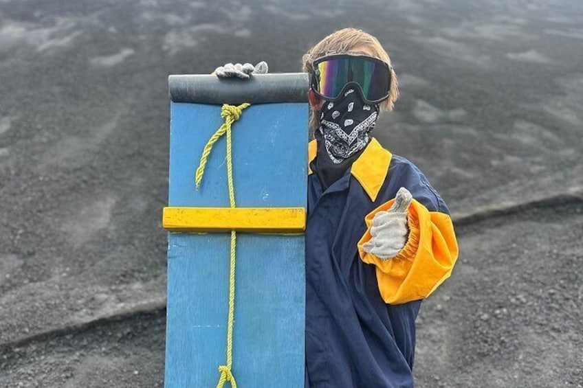 En person klädd i en blå och gul outfit som håller i en blå låda med gula remmar. 3