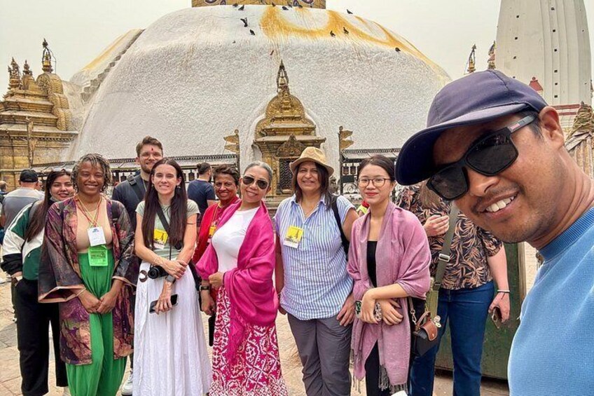 En grupp människor som står framför en stor byggnad med en gyllene kupol och intrikata arkitektoniska detaljer. 2