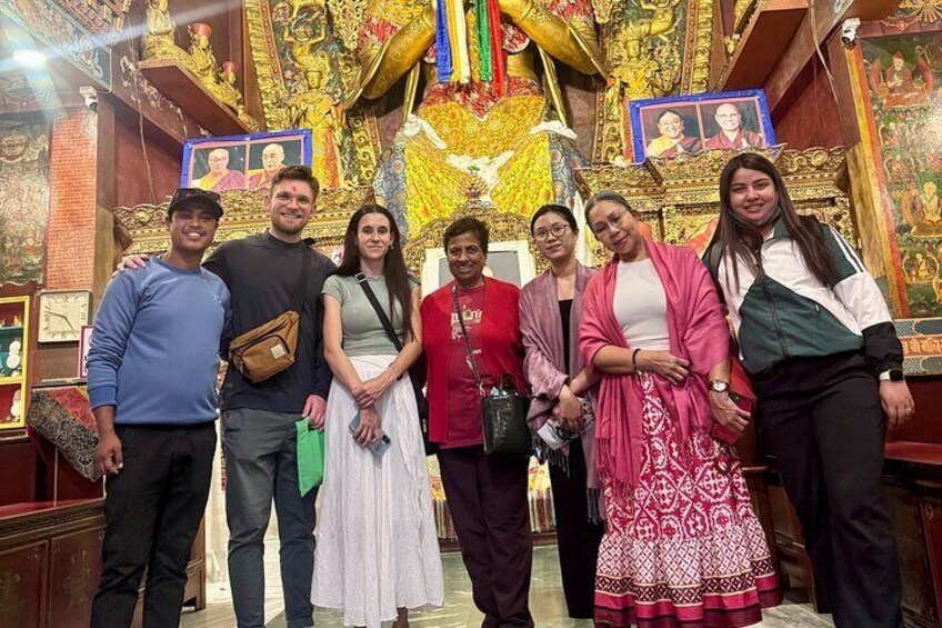Een groep mensen in een tempel met versierde decoraties en religieuze beelden. 2