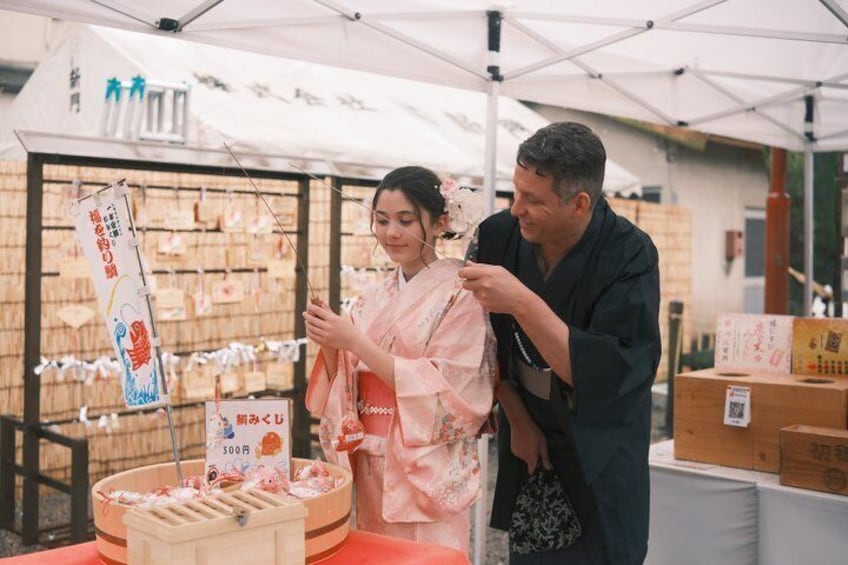 A person in traditional attire at a market stall with boxes and a sign. 3