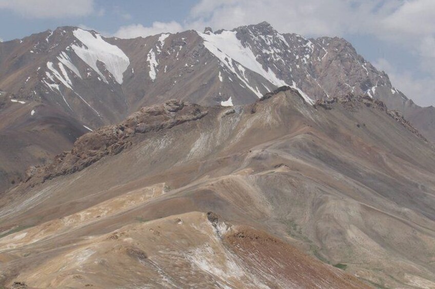 A mountain range with snow-capped peaks and a rocky foreground. 3