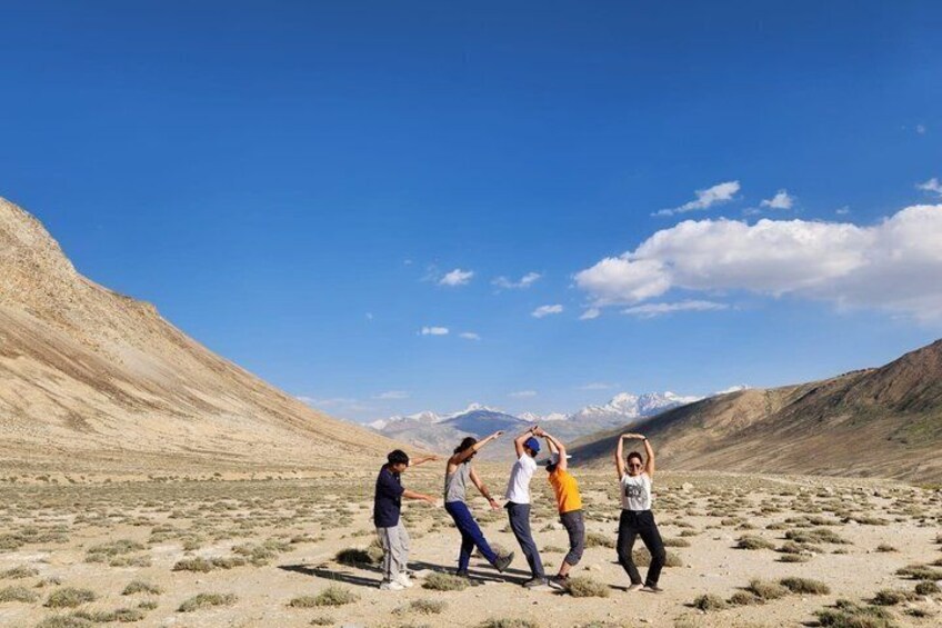 Four people in a desert landscape with mountains in the background. 2