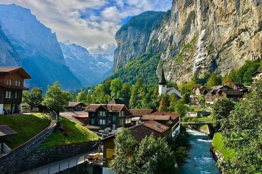 Un pueblo enclavado en un valle con un río, rodeado de montañas y vegetación. 5