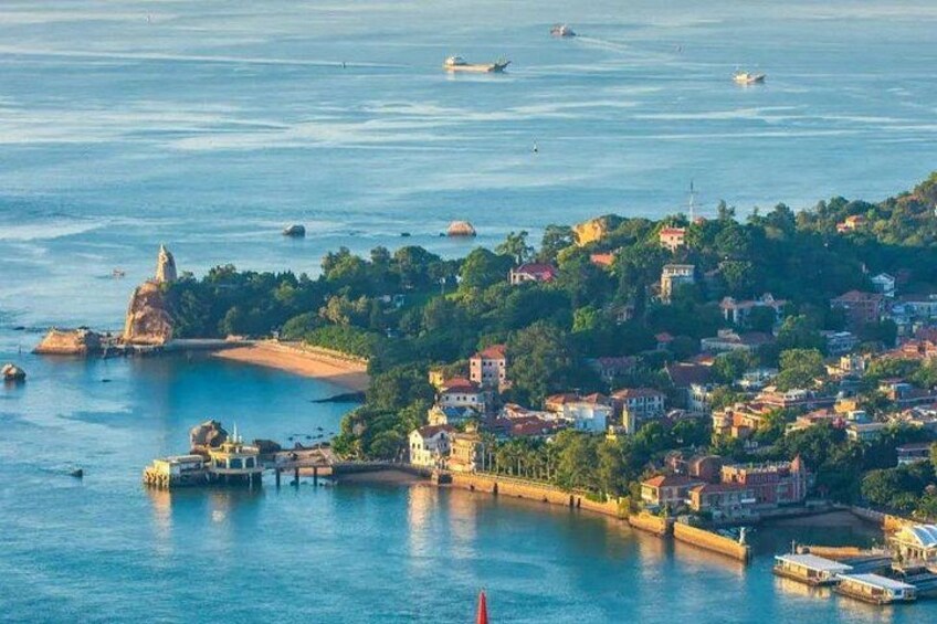 A coastal town with a prominent lighthouse, a harbor with boats, and a densely built-up area with buildings and greenery. 4