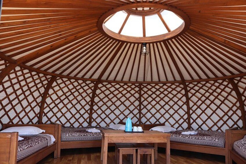 A round, wooden structure with a lattice ceiling and seating area. 2