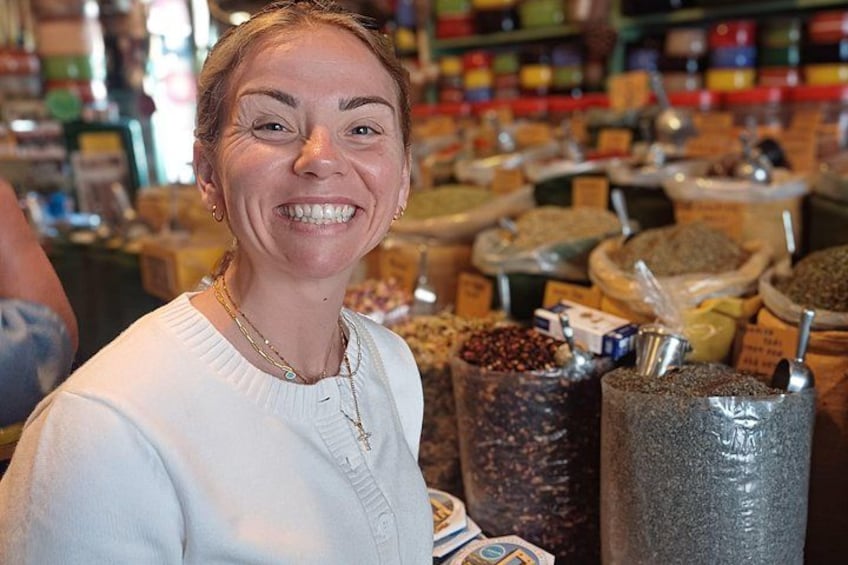 A person standing in a store with shelves of various spices and grains. 3