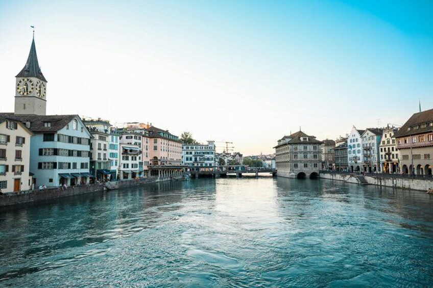 Un río con edificios a lo largo de sus orillas, una torre del reloj y un puente. 5
