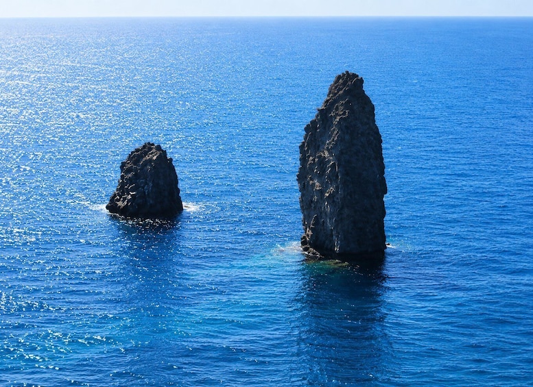 Two prominent rock formations in a clear blue sea. 5